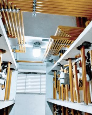 Nova tubulação de gás instalada em área técnica de edificação, com rede de tubos amarelos e medidores.
